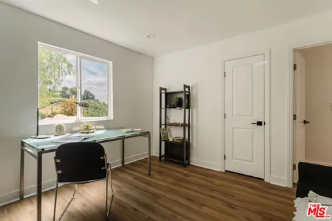 a view of a patio with table and chairs potted plants and large tree
