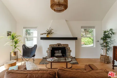 a living room with furniture a chandelier and a large window