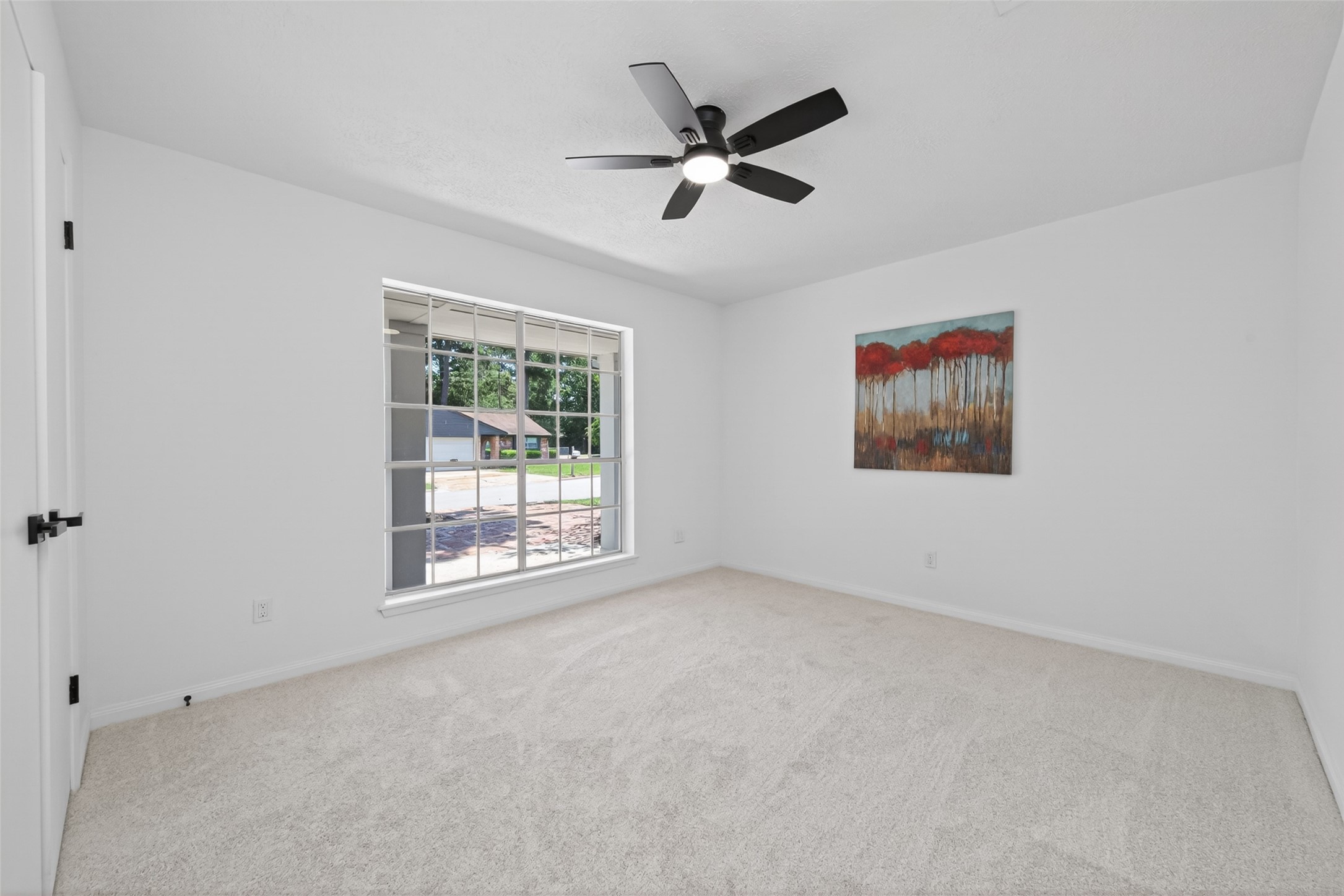 503 Allison Street Conroe, TX 77303 - Photo 15 of 34 Bright and inviting bedroom with large window and modern ceiling fan, perfect for creating a cozy personal retreat.