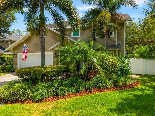 a view of a house with a yard and potted plants