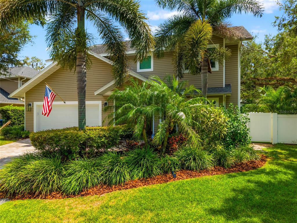 a view of a house with a yard and potted plants