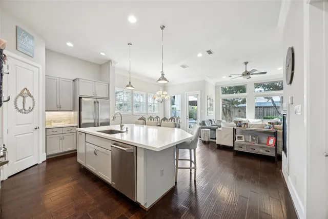 a large white kitchen with a stove a sink a refrigerator and furniture