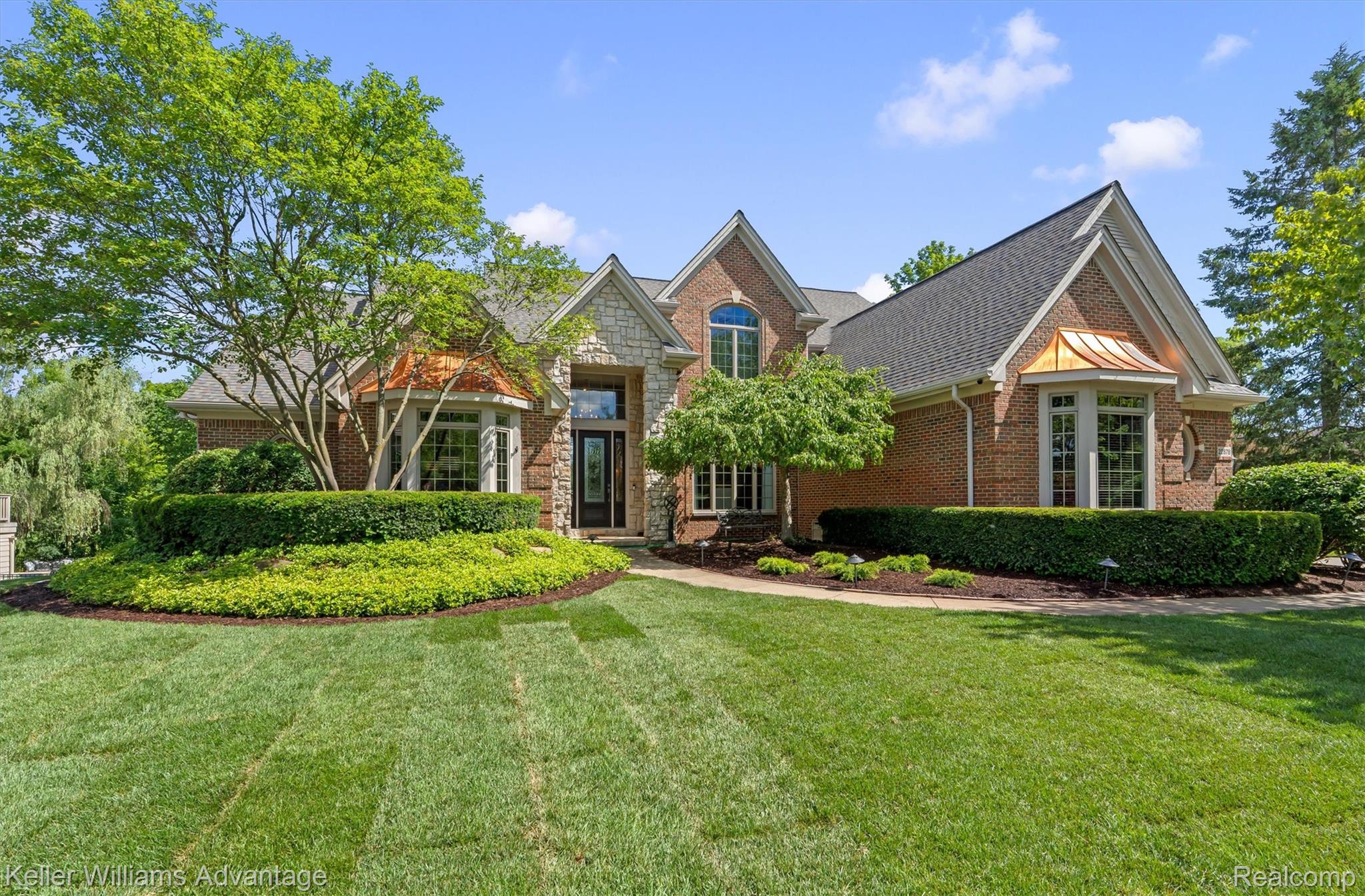 22878 Tree Top Court South Lyon, MI 48178 - Photo 63 of 75 Brick and stone exterior featuring a prominent gabled roofline