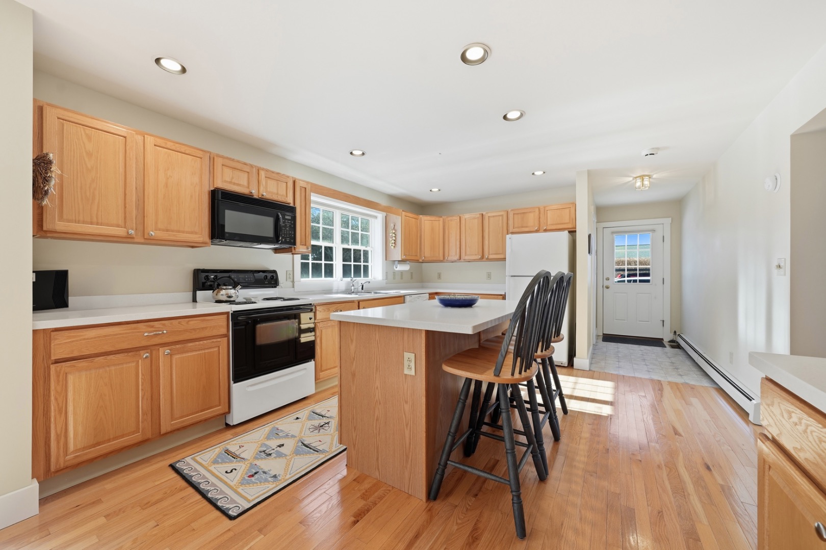 20 Rudder Lane Nantucket, MA 02554 - Photo 13 of 34 a kitchen with stainless steel appliances granite countertop a refrigerator a stove top oven a sink dishwasher and white cabinets with wooden floor