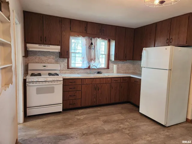 a kitchen with a stove a refrigerator and a sink