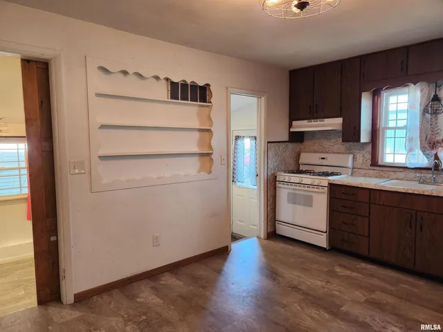 a kitchen with a white stove top oven and sink