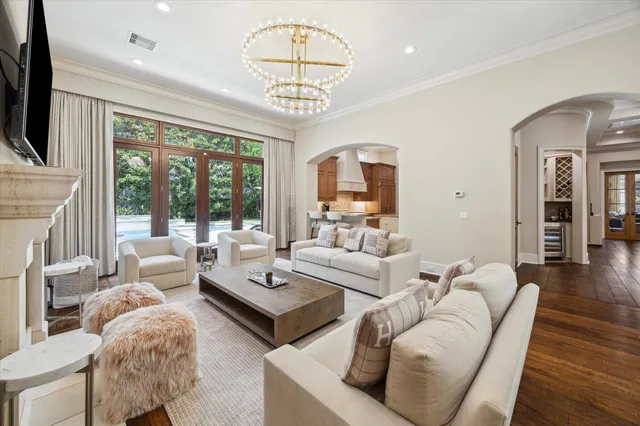 a living room with furniture a chandelier and a large window