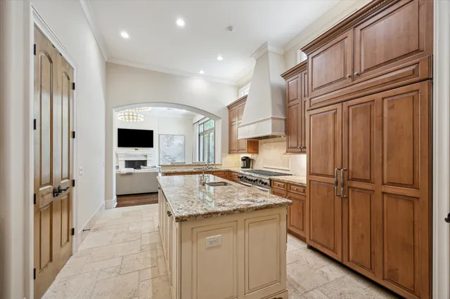 a kitchen with kitchen island granite countertop wooden cabinets and white appliances
