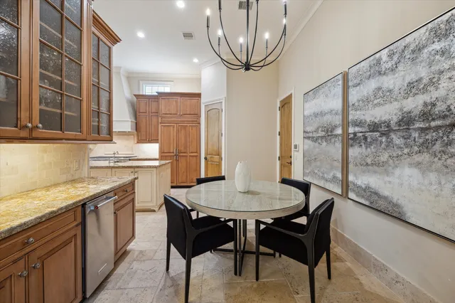 a kitchen with stainless steel appliances granite countertop a sink a stove a table and chairs