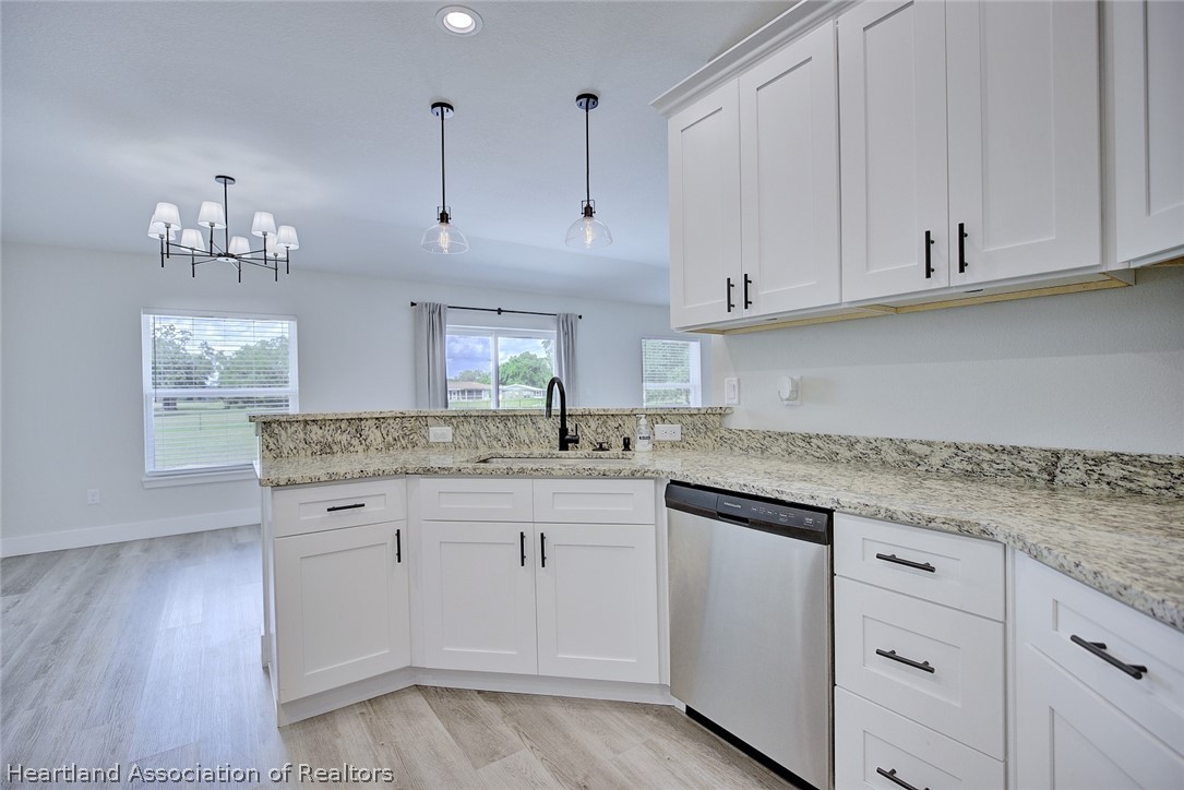 111 Vale Court Sebring, FL 33876 - Photo 12 of 40 a kitchen with white cabinets and sink