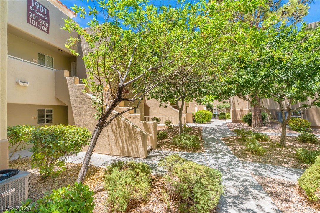 1901 Rio Canyon Court, Unit 102 Las Vegas, NV 89128 - Photo 2 of 23 A well-maintained common area offers shaded pathways and lush landscaping.