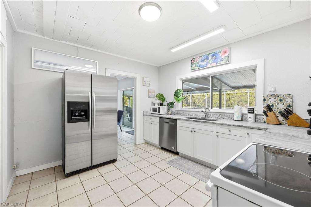 2347 Harbor Road Naples, FL 34104 - Photo 17 of 29 a kitchen with granite countertop cabinets and stainless steel appliances