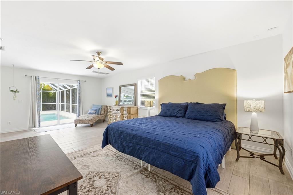 2347 Harbor Road Naples, FL 34104 - Photo 8 of 29 a bedroom with a large bed and a chandelier