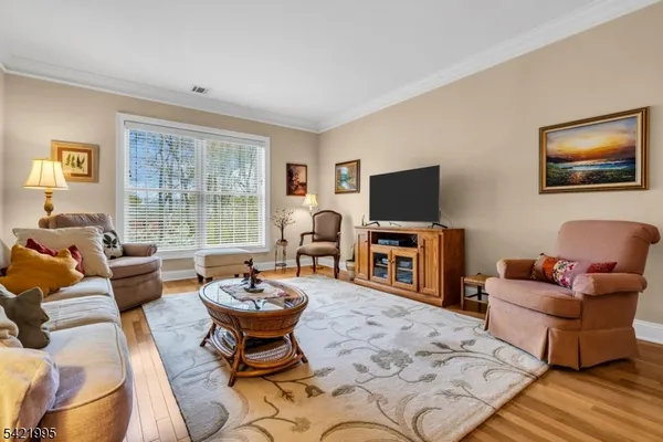 a living room with furniture a flat screen tv and a large window
