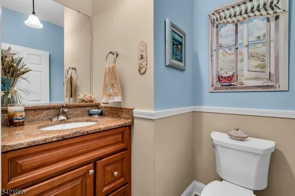 a bathroom with a granite countertop sink mirror vanity and toilet