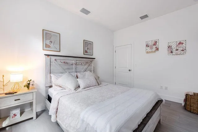 a bedroom with a bed and a painting on the wall