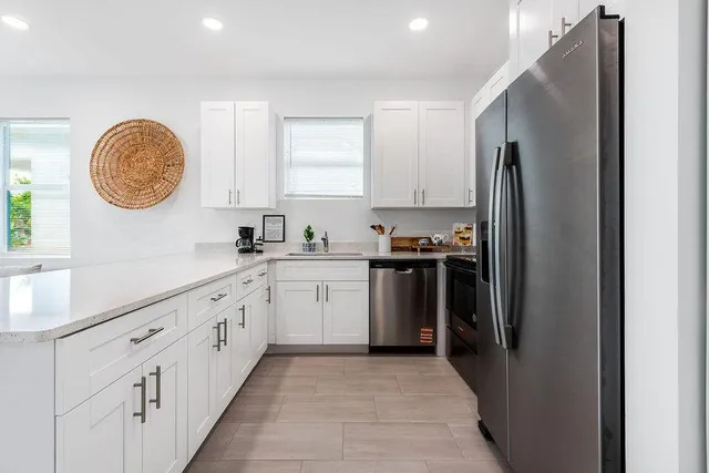a kitchen with granite countertop a refrigerator stove top oven and sink