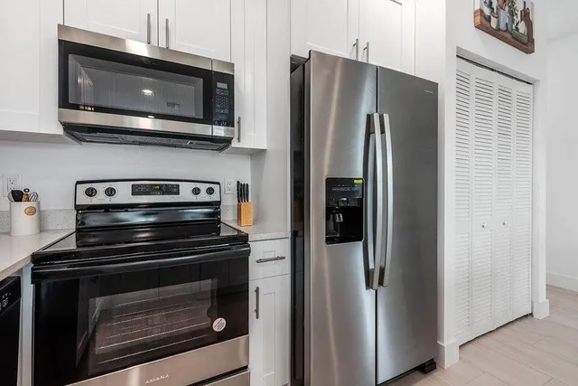 a kitchen with stainless steel appliances a stove microwave and refrigerator