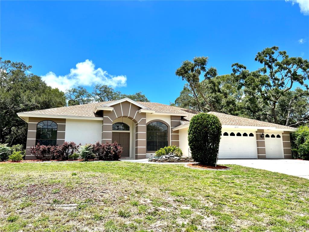 3015 Overview Lane Spring Hill, FL 34608 - Photo 1 of 1 a front view of a house with garden