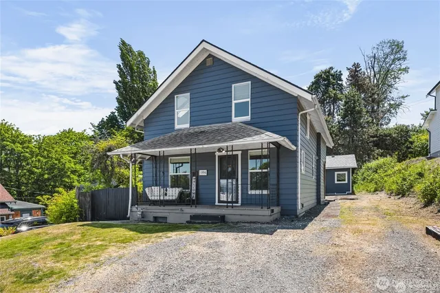 a view of a house with a yard and potted plants