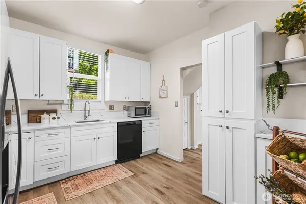 a kitchen with white cabinets and appliances