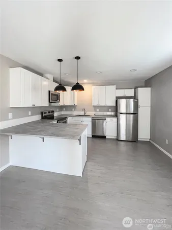 a kitchen with stainless steel appliances a stove top oven and white cabinets