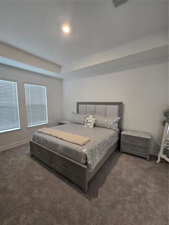a spacious bedroom with a bed and a window