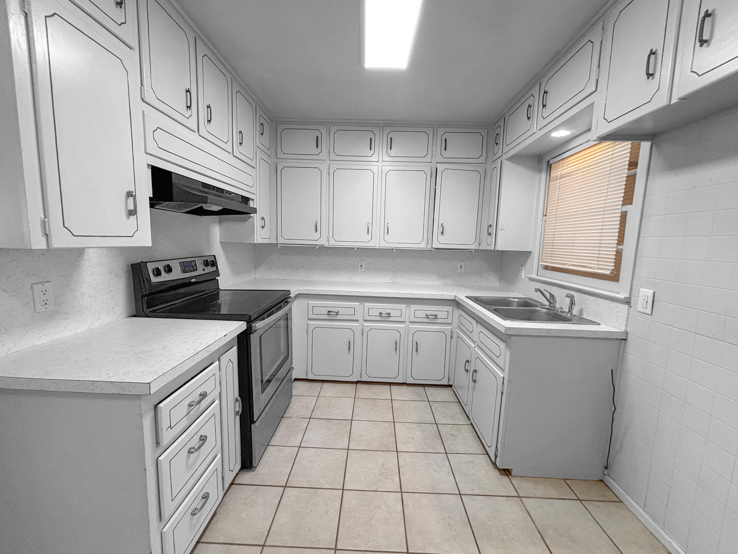 4411 45th Street Lubbock, TX 79414 - Photo 12 of 44 a kitchen with a sink dishwasher stove and white cabinets