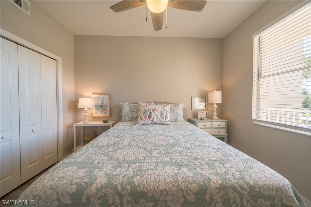 14101 Brant Point Circle, Unit 3203 Fort Myers, FL 33919 - Photo 29 of 34 a bedroom with a bed and a chandelier