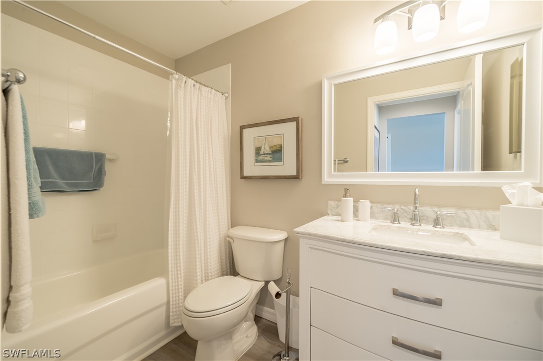 14101 Brant Point Circle, Unit 3203 Fort Myers, FL 33919 - Photo 31 of 34 a bathroom with a granite countertop toilet a sink and a mirror