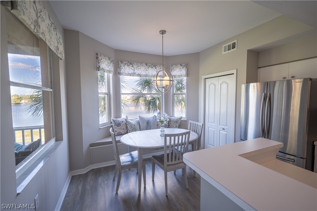 14101 Brant Point Circle, Unit 3203 Fort Myers, FL 33919 - Photo 4 of 34 a dining room with furniture a chandelier and wooden floor
