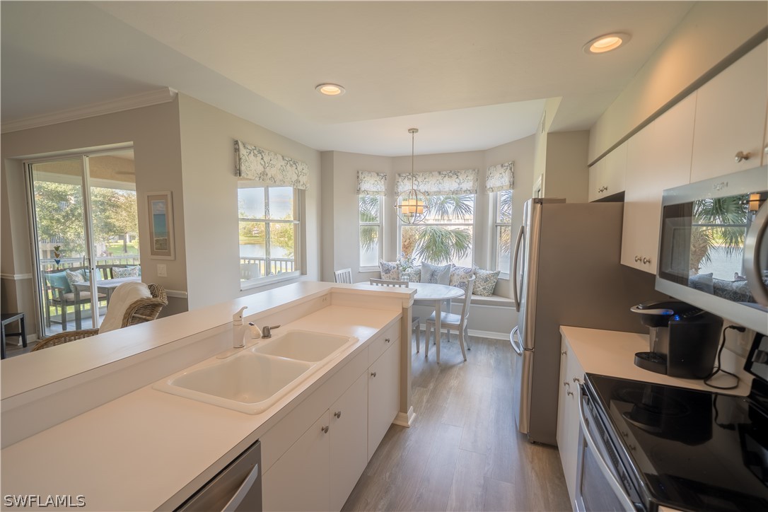 14101 Brant Point Circle, Unit 3203 Fort Myers, FL 33919 - Photo 6 of 34 a large kitchen with kitchen island a large window a sink and stainless steel appliances