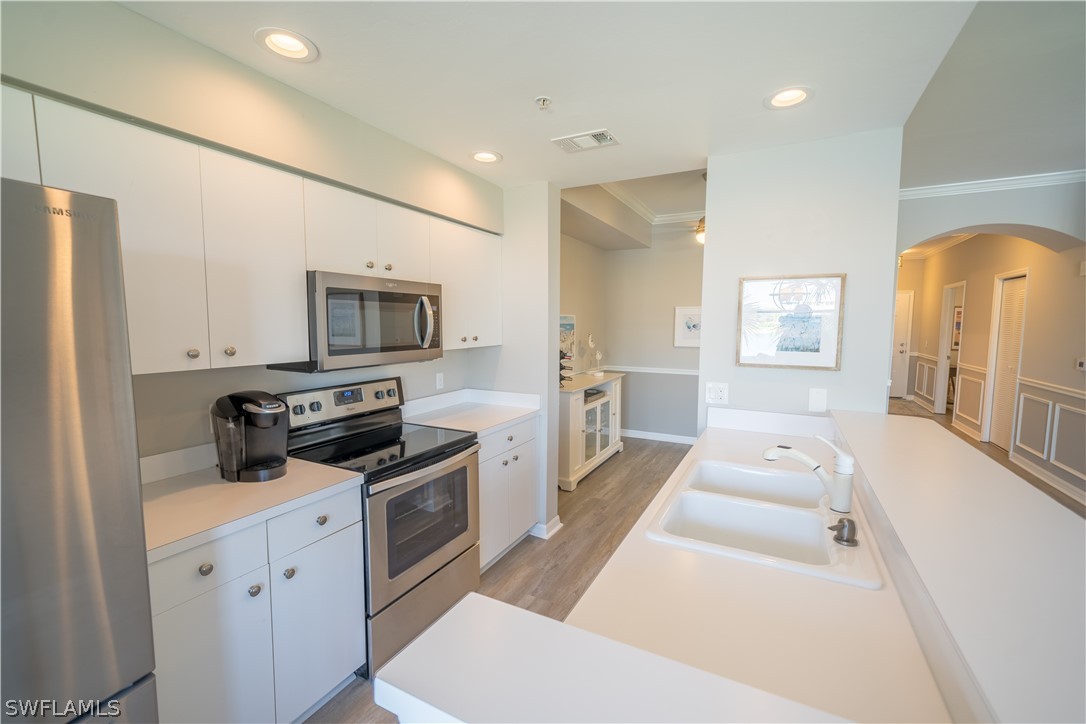 14101 Brant Point Circle, Unit 3203 Fort Myers, FL 33919 - Photo 8 of 34 a kitchen with a sink a counter top space stainless steel appliances and cabinets