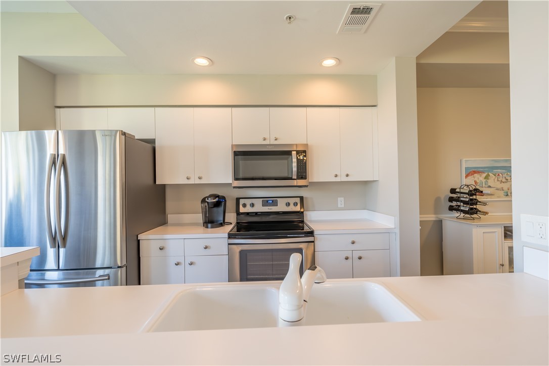 14101 Brant Point Circle, Unit 3203 Fort Myers, FL 33919 - Photo 10 of 34 a kitchen with stainless steel appliances a refrigerator stove and microwave