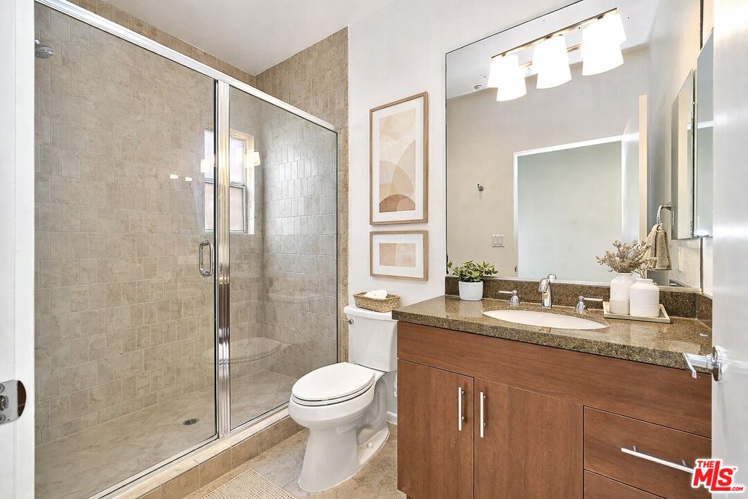 2864 Sunset Place, Unit 203 Los Angeles, CA 90005 - Photo 19 of 26 a bathroom with a granite countertop sink mirror toilet and shower