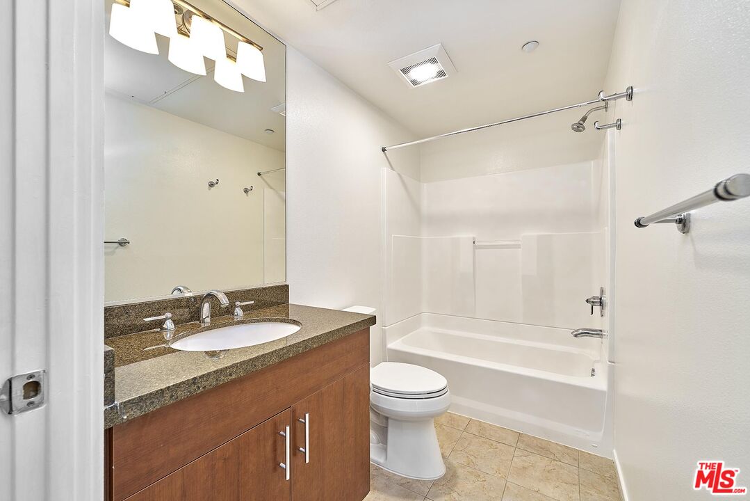 2864 Sunset Place, Unit 203 Los Angeles, CA 90005 - Photo 22 of 26 a bathroom with a granite countertop sink toilet and shower