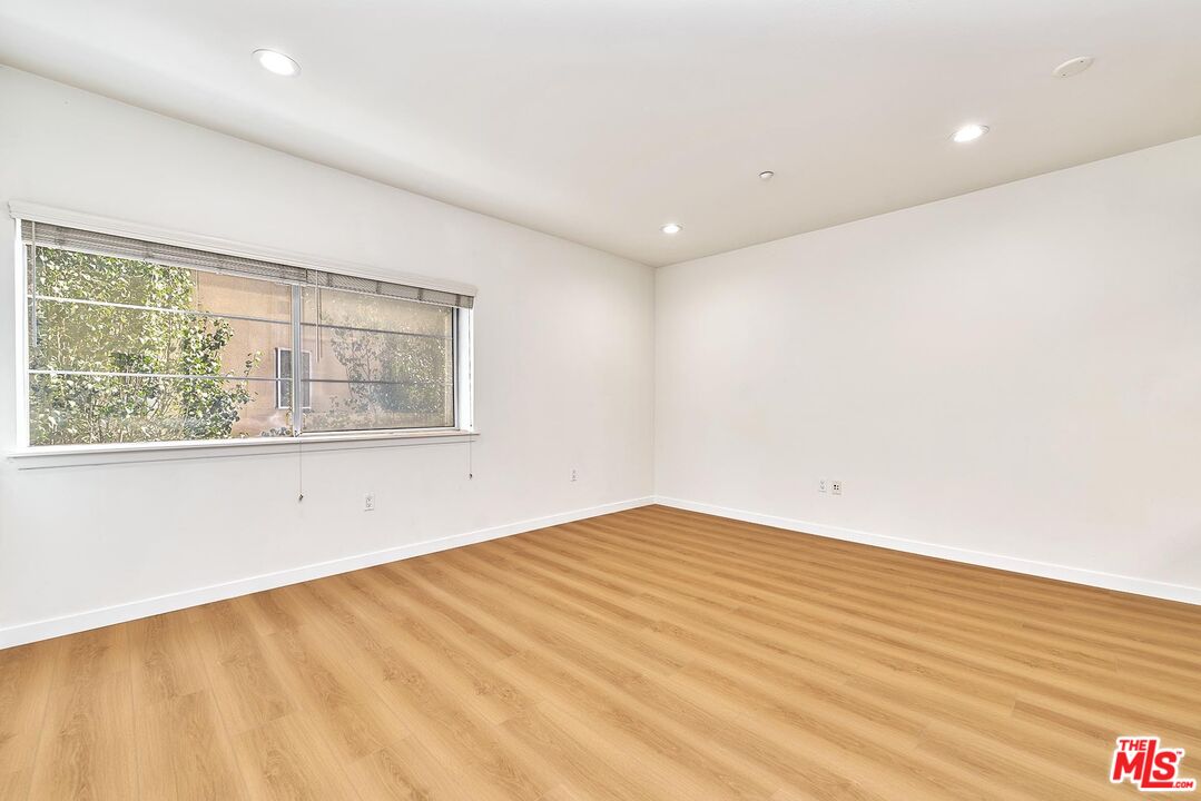 2864 Sunset Place, Unit 203 Los Angeles, CA 90005 - Photo 5 of 26 an empty room with wooden floor and windows