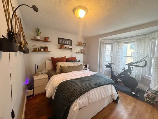 a bedroom with a bed and wooden floor
