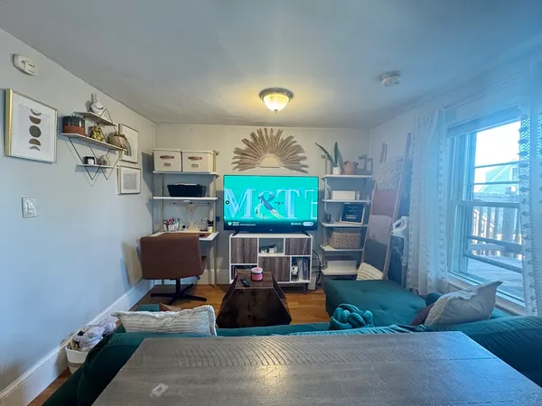 a living room with furniture a air conditioner vent and a window