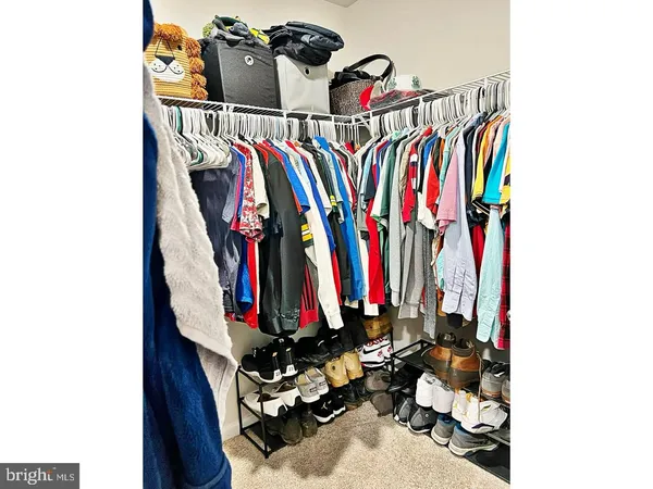 a view of walk in closet with clothes and shoes