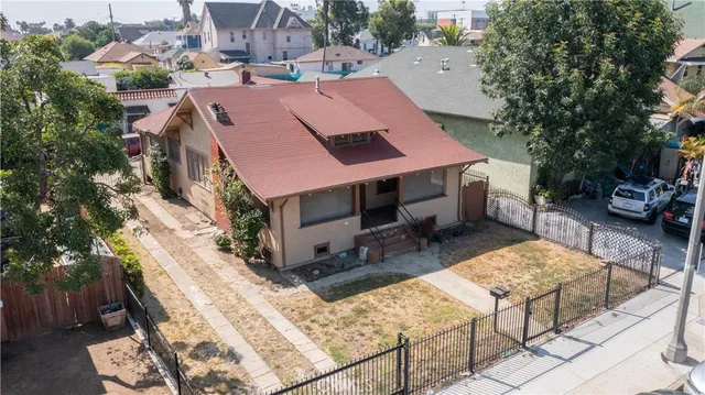 an aerial view of a house with wooden deck and furniture