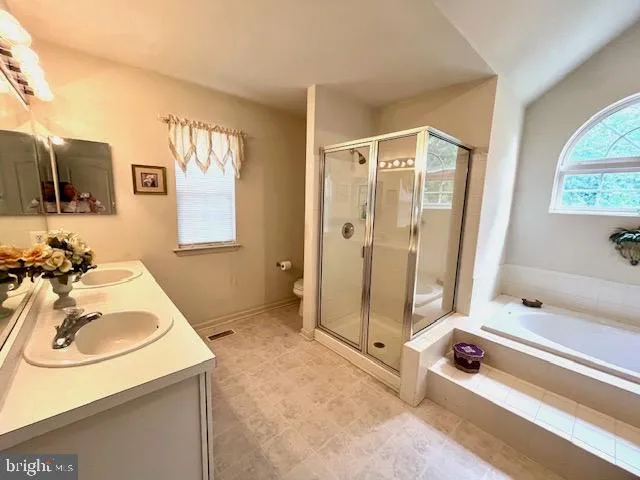 a bathroom with a tub a sink and a mirror
