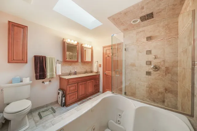 a bathroom with a granite countertop toilet sink and shower