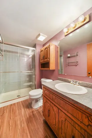 a bathroom with a granite countertop sink toilet a large mirror and shower