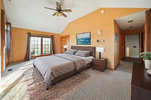 a bedroom with a large bed and a chandelier