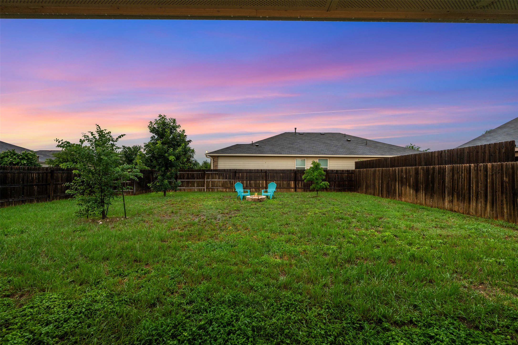 14900 Retha Pass Austin, TX 78725 - Photo 6 of 39 Expansive backyard featuring a lush lawn, privacy fencing, and trees