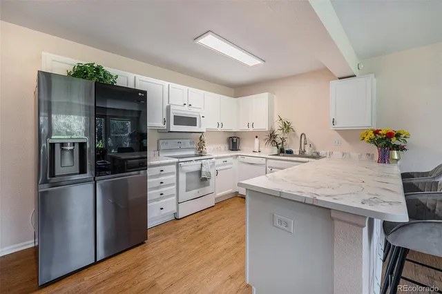a kitchen with stainless steel appliances kitchen island a refrigerator sink and cabinets
