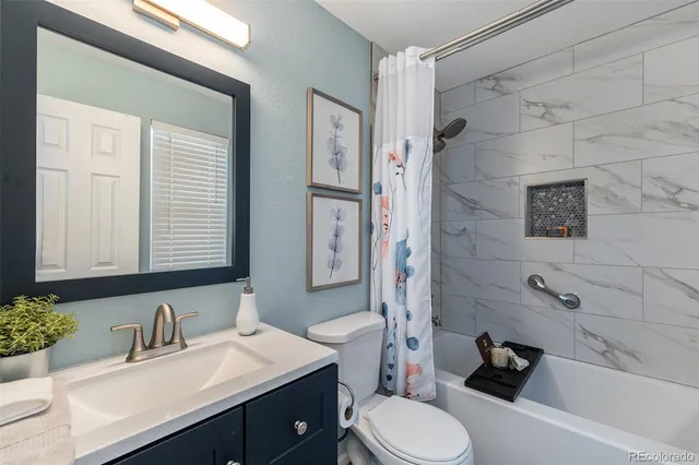 a bathroom with a granite countertop sink toilet a mirror and shower