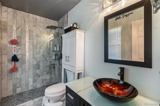 a bathroom with a sink a toilet and shower