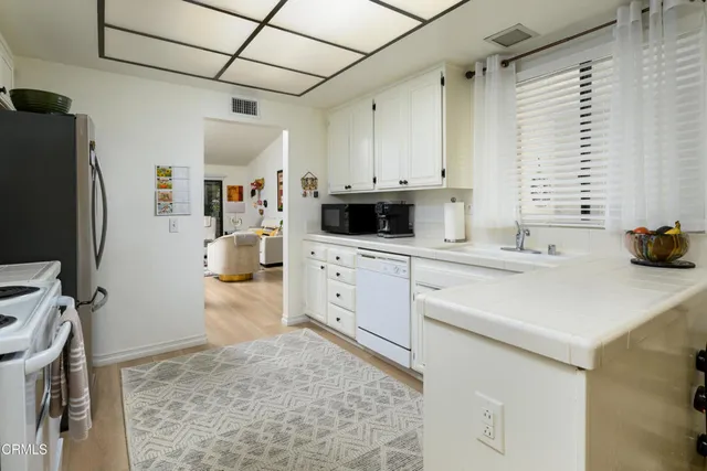 a kitchen with stainless steel appliances a stove a sink and a refrigerator